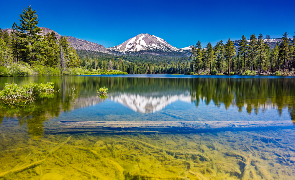On this lovely day, Lassen Peak was perfectly mirrored in Manzanita Lake. The sky was as blue as the summer sea, the trees were as green as the newly mown lawn, and the water was as clear as crystal.